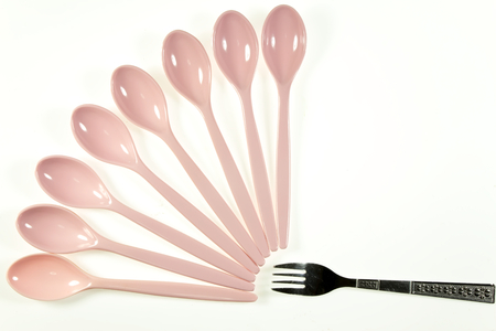 Pink plastic spoon and fork isolated on white backgroundの写真素材