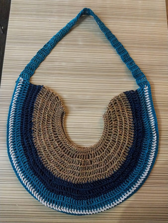 Cotton handbag made of natural yarn on a bamboo mat.