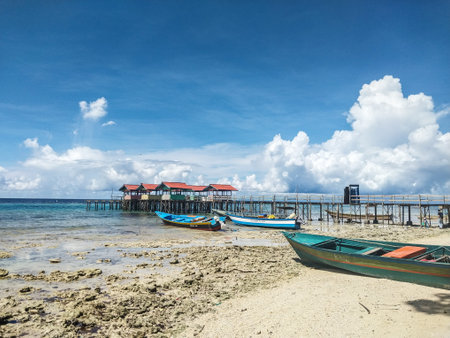 Fishing boats on the tropical beach with blue sky and white clouds