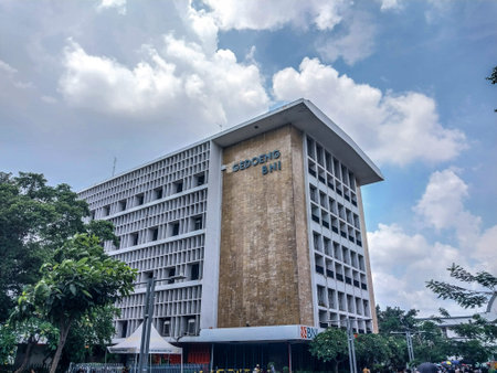 A male tourist in casual attire and sunglasses poses in front of the Jakarta History Museum