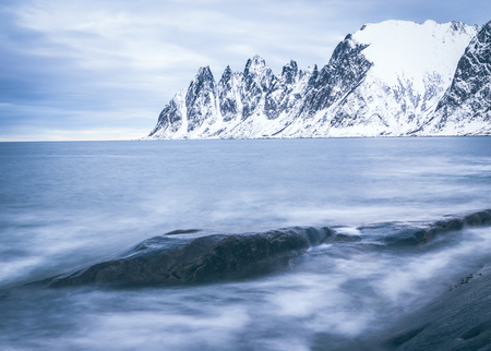 Sharp mountain's range  rising from northern sea. Frosty day at Tungenesetの写真素材