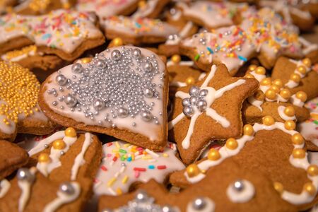 Many colorful handmade gingerbread cookies baked and decorated for Christmas Holidays. Silver and...