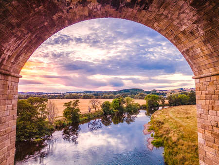 Aerial view through an arch of Arthington Viaduct upriver on River Wharfe. High quality photoの写真素材