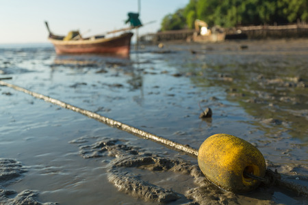 yellow buoy and Coastal Fishing Boatson a beachの写真素材