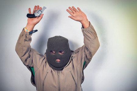 thief and gun in his hand show up over headの写真素材