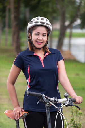 a beautiful sport women and bicycle smile in the gardenの写真素材