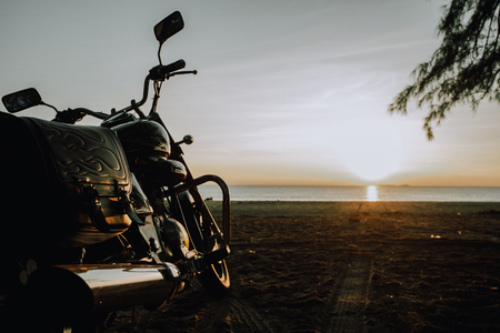 A beautiful motorbike parked on the beach at the sunrise.の写真素材