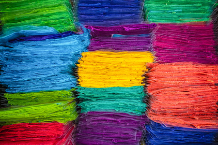 The fabric is folded in a variety of bright colors stacked together.