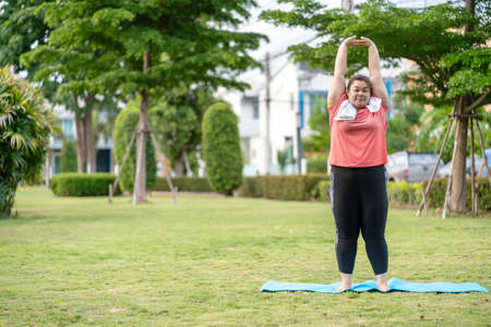 new normal concept,Young woman is happy to motivation exercise or yoga outdoor in the garden to...