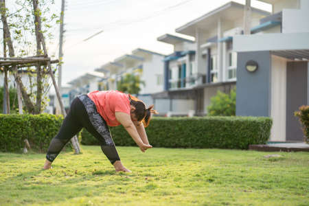 new normal concept,Young woman is happy to motivation exercise or yoga outdoor in the garden to control or lose weight.Obese fat woman have intention exercise to lose weight and build strong health.の写真素材