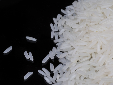 The main food of asian people, rice. There storage lots of energy from carbohydrate. The plenty of rice of the black backgroundの写真素材
