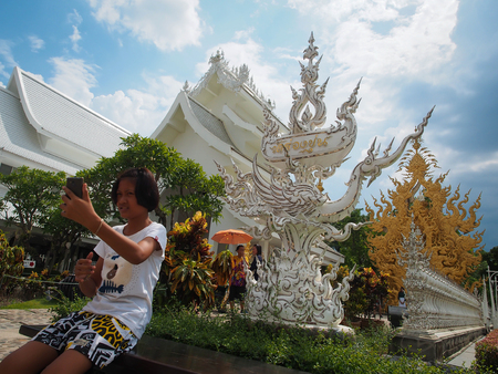 Chaingrai, Thailand - May 30, 2015 : The girl is selfie with the sign of Rong Khun temple.のeditorial素材