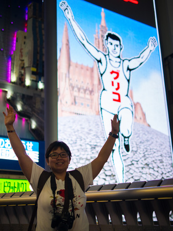 Osaka, Japan - Jun 6, 2016 : A traveler is acting similar to Glico sign, the landmark sign of Dotombori area in Osaka, Japan.のeditorial素材
