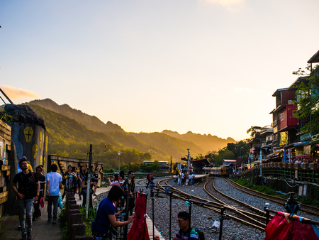 Shifen, Taiwan - Nov 17, 2016 : The tradition train is incoming to Shifen station where it is the popular traveling place for tourist. The vanilla sky is also nice with hill behind the crowded area.のeditorial素材