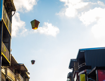 Above the shopping area of Shifen waterfall, the wishing hot air balloon from the tourists are floating up to the sky. Nice moment to look at with the sunlight hitting it alone with the buildings,の写真素材