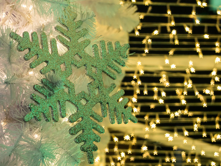 The selective focus of snowflake with the background of yellow star shape bokeh along the wires of christmas decoration. Merry Christmas everyoneの写真素材