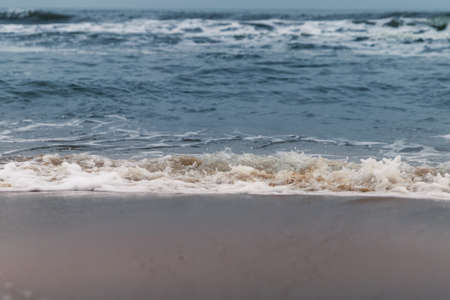 Ocean Waves and Foam hitting sandy beach in North Carolina at Sunsetの写真素材