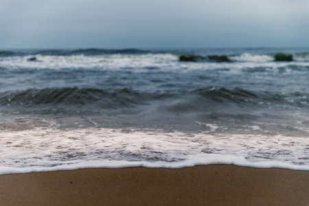 Ocean Waves and Foam hitting sandy beach in North Carolina at Sunsetの写真素材