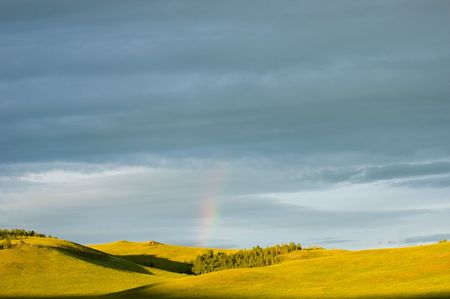 rainbow, hill and cloudy skyの写真素材