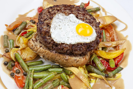 Grilled steaks,fried egg and vegetablesの写真素材
