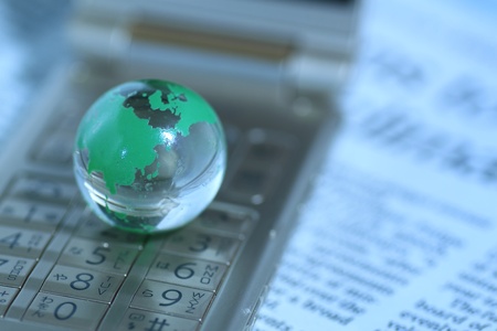 Glass globe over cellphoneの写真素材