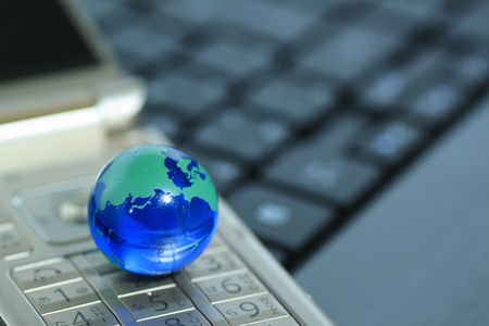 Glass globe over cellphoneの写真素材