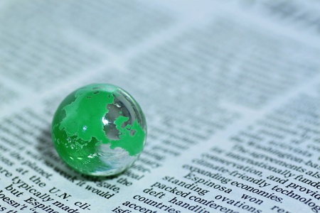 Glass globe over newspaperの写真素材