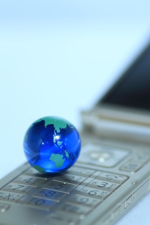 Glass globe over cellphoneの写真素材