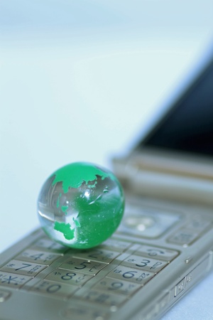Glass globe over cellphoneの写真素材