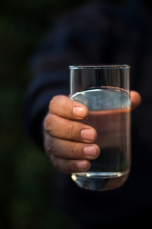A person holding a glass of drinking water.の写真素材