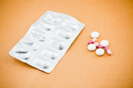 Medical drugs and pills isolated on brown background.の写真素材