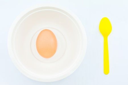 Brown Egg in a Bowl Isolated on White, Yellow spoon and put it aside 