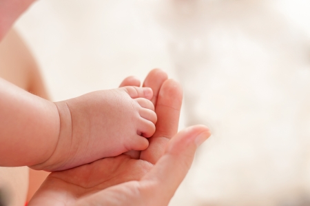 mother hold feets of newborn babyの写真素材