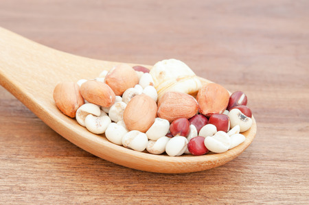 Various seeds and grains close up on wooden spoon