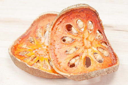 Close up slices of dried bael fruit on wood floor.の写真素材