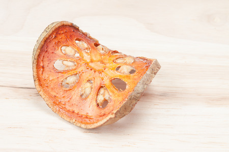 Close up slices of dried bael fruit on wood floor.の写真素材