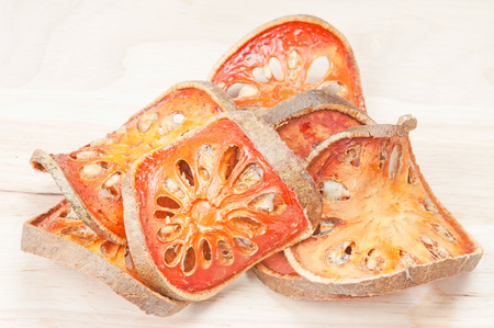 Close up slices of dried bael fruit on wood floor.の写真素材