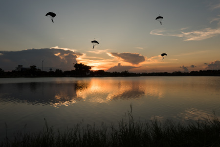 parachute silhouetted with river landscape at sunset