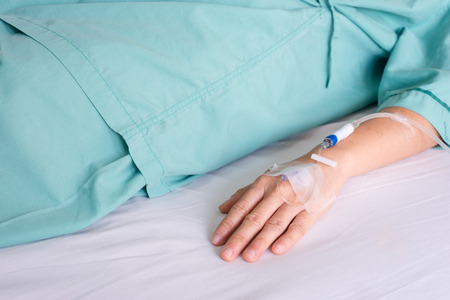 Hand of woman with drip in hospital bedの写真素材