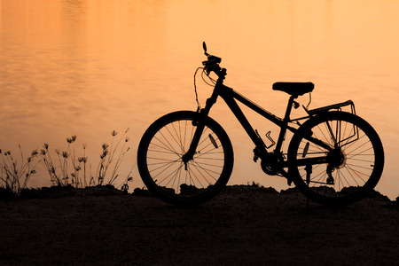 Silhouette of bike near the lakeの写真素材