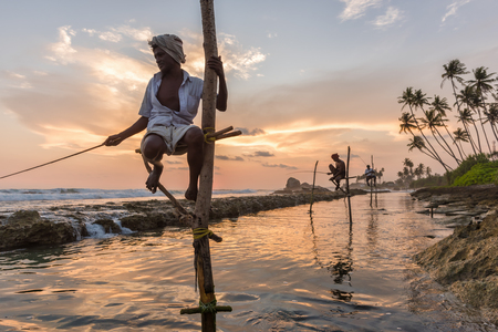 KOGGALA, SRI LANKA - MARCH 22, 2016: Local men fishing in traditional way. traditional fishermen at the sunset near Galle in Sri Lanka.のeditorial素材