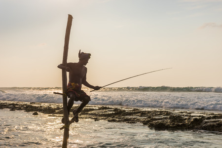 KOGGALA, SRI LANKA - MARCH 22, 2016: Local men fishing in traditional way. traditional fishermen at the evening near Galle in Sri Lanka.のeditorial素材