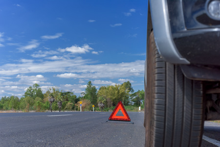 Red emergency stop sign and broken car on the roadの写真素材
