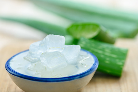  Aloe vera gel on bowl with fresh aloe vera leaves on wooden backgroundの写真素材
