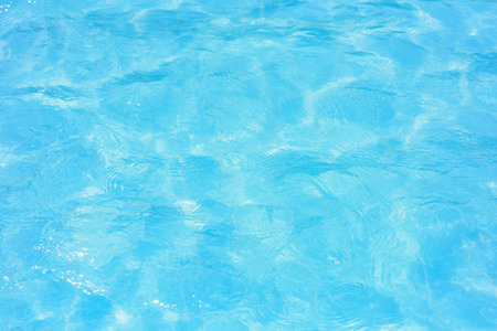 Ripple water in swimming pool with sun reflectionの写真素材