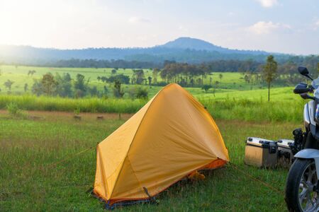 Camping and tent middle of the meadow with motorbike in sunset.の写真素材