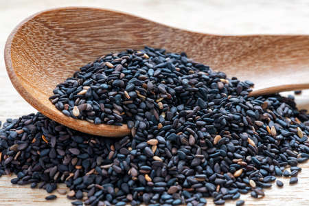 Black sesame seeds in wooden spoonの写真素材