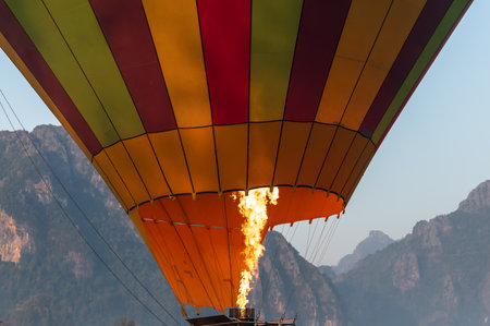 Hot air balloon flight over ground. Inflating the hot air balloon in a green field before the flight over ground.の写真素材