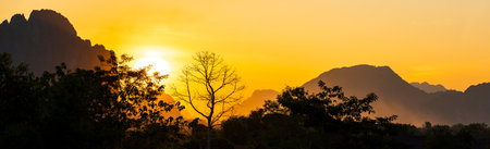 Beautiful natural panoramic countryside landscape with mountains at sunset. Rainforest ecosystem and healthy environment concept background. Top view forest and mountain. Nature background.の写真素材