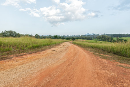 Landscape of gravel road in countryside with blue sky. Road in rainy season. Side view of dirt road on top mountain. road background.の写真素材